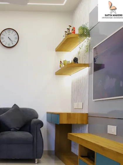 A cozy corner featuring a comfortable armchair next to a custom-designed media unit with illuminated display shelves.