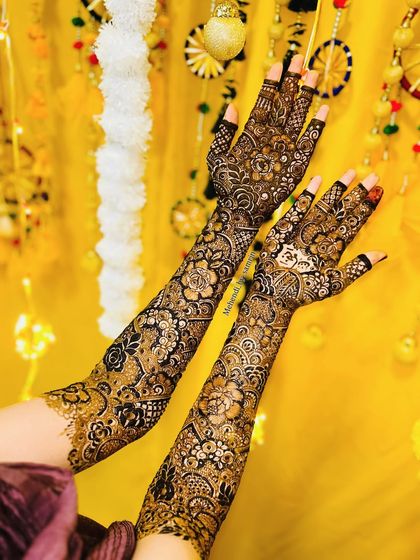A stunning bridal floral design, captured against a vibrant yellow Haldi backdrop. The intricate patterns look absolutely radiant.