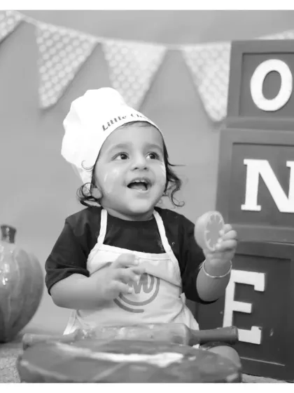 A joyful black and white shot of our 'Little Chef' during a first birthday shoot. Monochrome can emphasize expression and emotion.