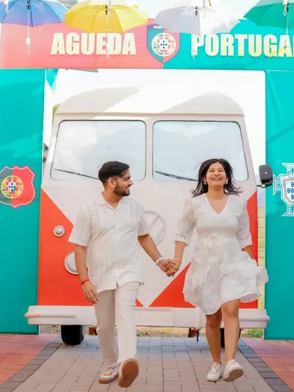 A fun, dynamic shot of the couple walking through a colorful, Portugal-themed alleyway. This set offers a unique and vibrant background for a pre-wedding shoot that feels like a European holiday.