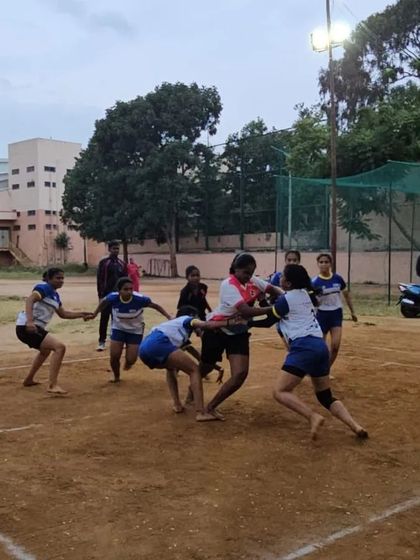 An action shot from a girls' practice match, showing a raider trying to break through the defensive chain.
