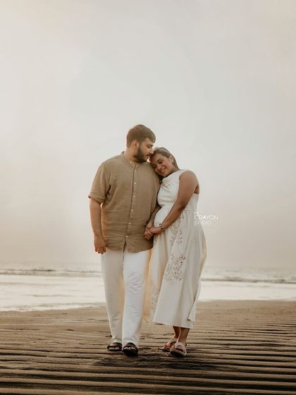 A quiet walk along the shoreline at sunset. The soft light and serene atmosphere make this a romantic and timeless couple maternity portrait.