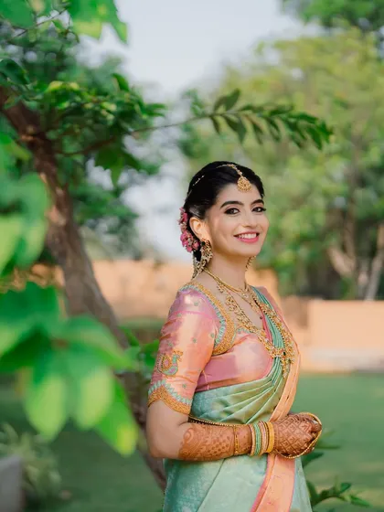 Nidhi surrounded by nature, looking effortlessly beautiful on her wedding day. The makeup is designed to look just as good outdoors in natural light.
