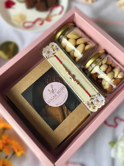 The 'Raksha Delight' hamper box, containing assorted brownies and jars of roasted nuts and butter cookies. A perfect gift for your sibling.
