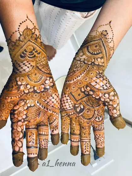 An intricate bridal henna design covering the entire palm and fingers. The detailed patterns and shading are made possible by the professional quality of my organic henna cones.