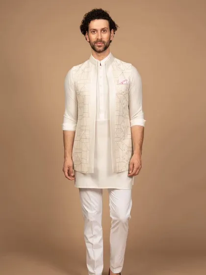 A dashing all-white ensemble perfect for making a lasting impression. This look, featuring a geometric embroidered Nehru jacket, is a modern heirloom in the making, ideal for daytime ceremonies.