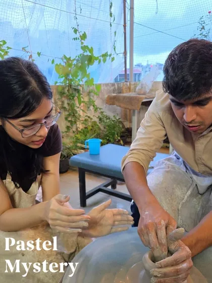 I provide hands-on guidance to make sure everyone feels comfortable, like in this shot where I'm helping a couple get their start on the pottery wheel.