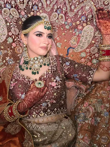 A close-up of the peacock lehenga, showing the detailed embroidery and the bride's pose.