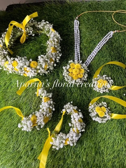 A bright and sunny Haldi set made with yellow flowers and baby's breath. The yellow ribbons add a festive touch.