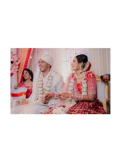 A candid shot of the couple seated during their ceremony, sharing a laugh. This photo captures the joy and relaxed atmosphere of their wedding.
