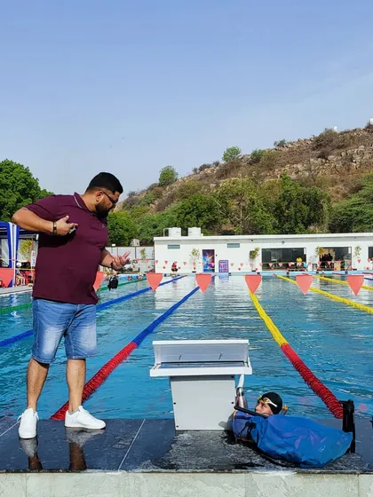 Chasing excellence, one-hundredth of a second at a time. Here I am timing a swimmer during a practice set, providing immediate feedback to ensure they are hitting their target pace and maintaining perfect form.