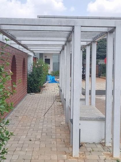 A completed section of the covered walkway at Aamby City, with established hibiscus bushes.