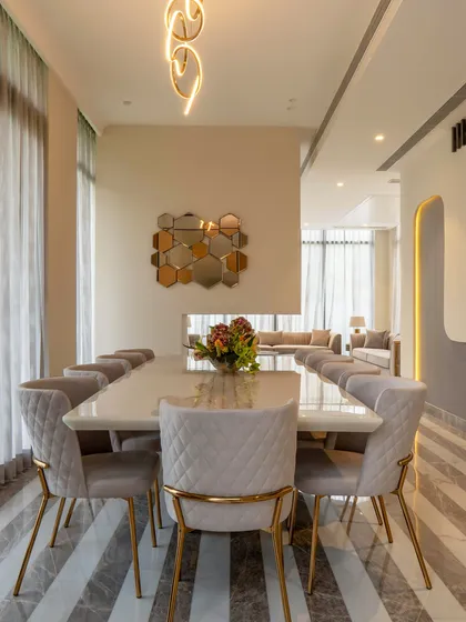 A different angle of the tranquil dining area, showing the modern lighting fixture that adds a sculptural element. The design is a perfect balance of clean lines and soft, luxurious textures.