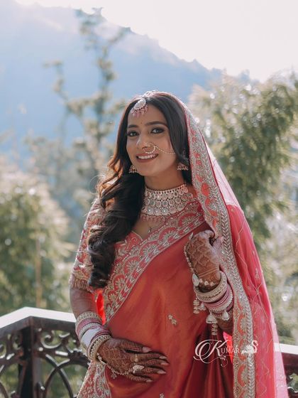 A beautiful outdoor portrait of a bride against a mountain backdrop, smiling warmly.