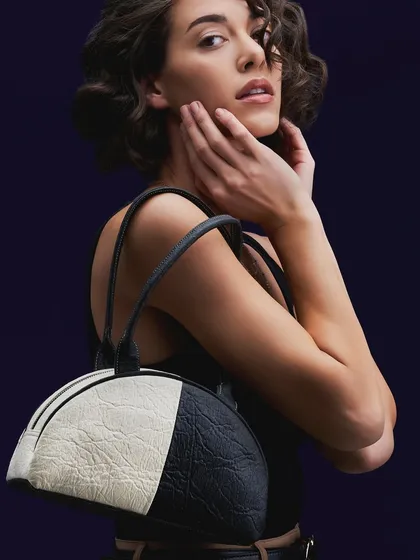 Another shot for A Big Indian Story, showcasing a different style of their sustainable leather bags. The lighting is soft and flattering, highlighting both the model and the product.