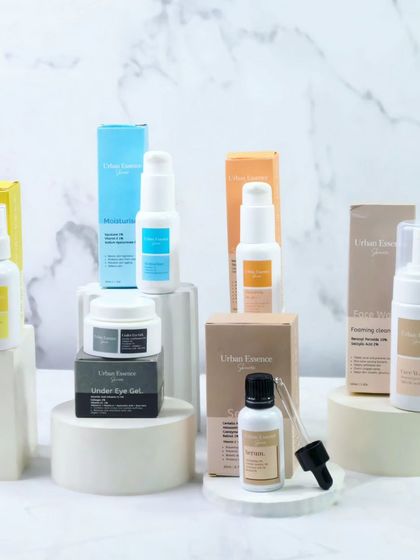 Here, the skincare products are displayed with their packaging on staggered white risers. This gives a complete view of the brand's offering against a clean, marble background, looking both professional and aesthetic.