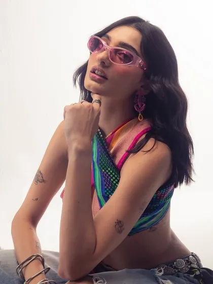 This look, with the pink sunglasses and colorful top, is pure Y2K vibes. I draw a lot of inspiration from different eras of fashion and music.