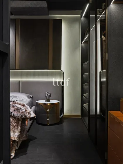 This bedroom is artfully designed to evoke opulence with premium furniture. The space features a circular bedside console and elegant back-painted wardrobe shutters, reflecting a lifestyle of luxury while meeting the demands of modern living.