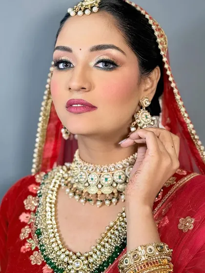 Another angle of the traditional red bridal look, showing the flawless contour and highlight that defines the bride's features.