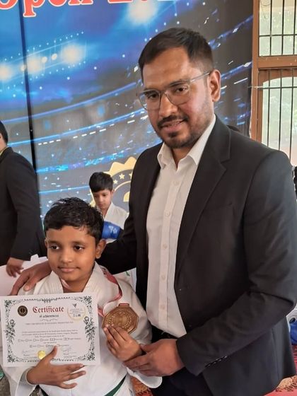 A coach celebrating with a young medalist. The bond between coach and student is fundamental to success.