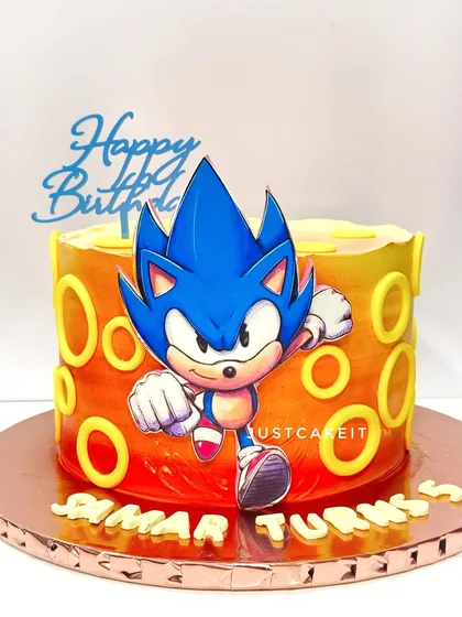 A Super Sonic the Hedgehog theme cake. The fiery orange and yellow airbrushed background gives a sense of speed, and it held up perfectly even after travelling in heavy rain.