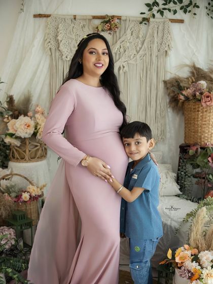 A heartwarming portrait of a mother and her older son. He hugs her baby bump, excited to become a big brother.