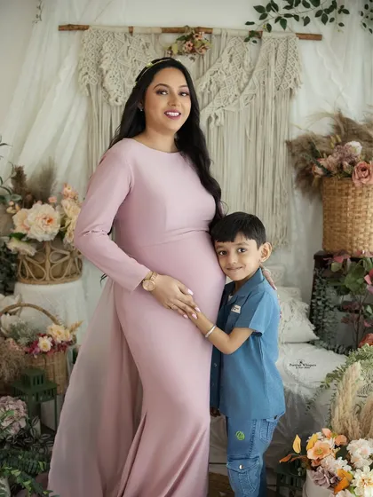 A proud big brother-to-be hugs his mom's belly. This portrait captures the beautiful bond between a mother and her son as they await the newest family member.