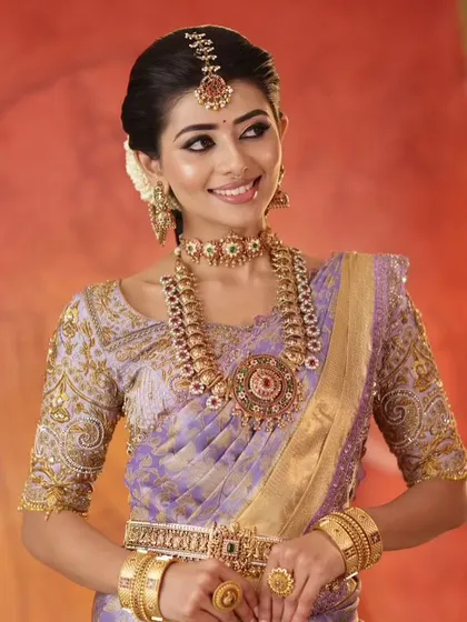 A stunning look featuring a lavender Kanjeevaram silk saree paired with a heavily embroidered custom blouse. This combination is timeless, elegant, and perfect for a wedding muhurtham or reception.