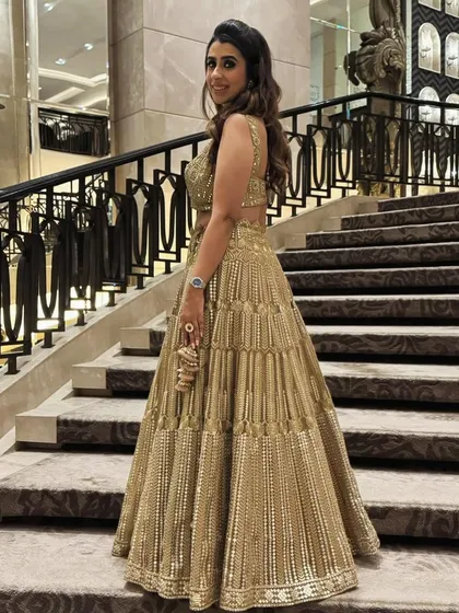A full-length view of the soft waves I created for a high-profile wedding event. The hair is styled to look full and healthy, cascading down the back to complement the stunning gold lehenga.