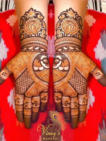 A full view of the designer short-hand mehndi, showing the symmetrical peacock and lotus design across both hands.