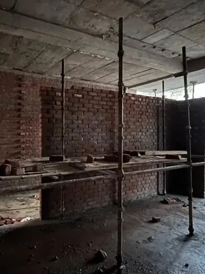 The interior space taking shape with scaffolding in place. This view shows the concrete slab ceiling and brick walls, the basic shell that we will transform into a refined living space.
