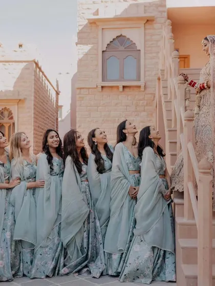 A beautifully composed shot of the bride with her bridesmaids against the sandstone architecture of the fort. This image captures the friendship and excitement of the bridal party.