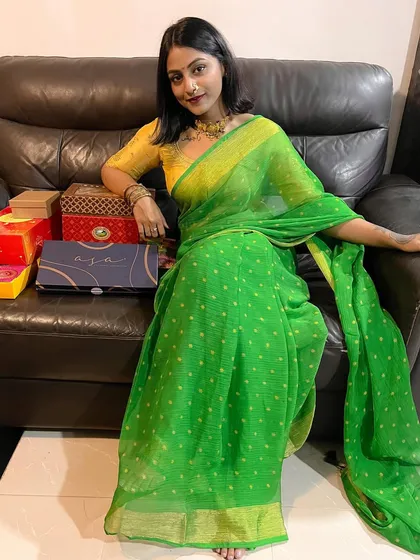 Relaxing at home during Diwali, surrounded by gifts. The vibrant green of the saree brings such a joyful and festive energy.