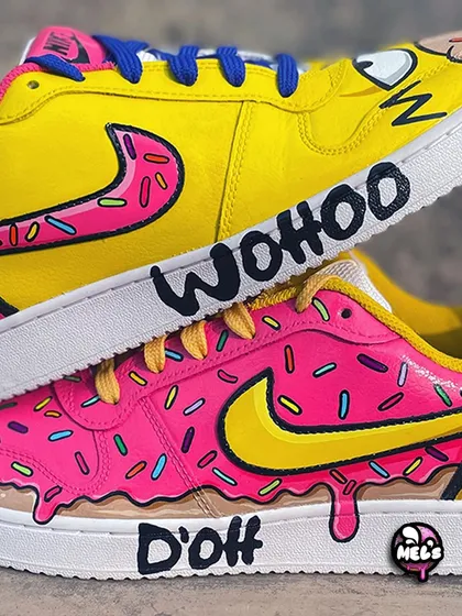 A close-up of the stacked Simpsons sneakers, highlighting the "WOOHOO" and "D'oh" quotes on the midsoles.