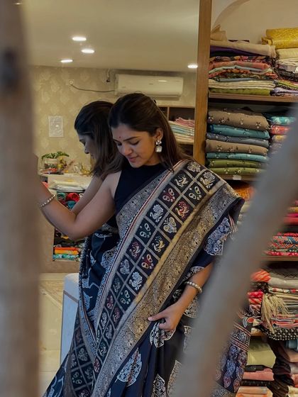A Dola silk saree featuring an Ajrakh hand-block print and a Bentex border. The intricate patterns and rich colors make this a truly special piece.
