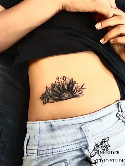 This sunflower tattoo was designed to cover up a name on the client's side. The dark center and shaded petals provide perfect coverage for a fresh start.