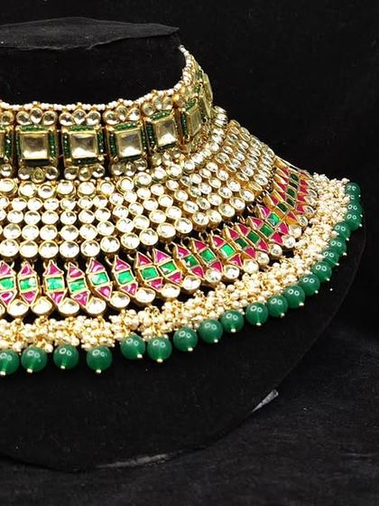 A grand bridal choker with layers of green and pink stones, offering a colourful and festive look.