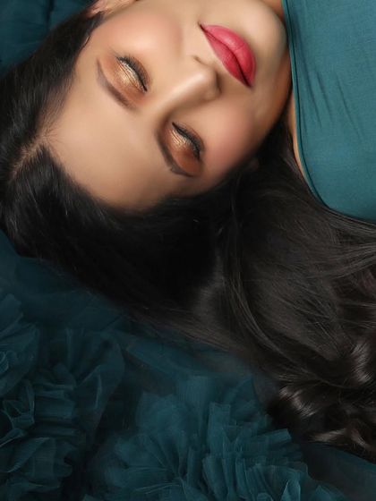 A close-up shot capturing the serene beauty of a mom-to-be, lost in a moment of peace. The focus is on her calm expression and the rich texture of her gown.