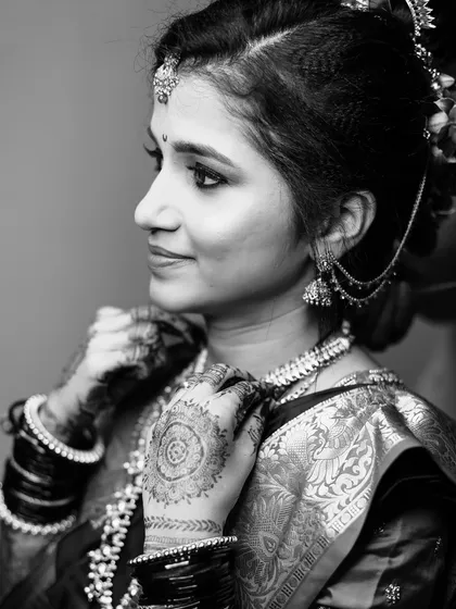 A classic black and white portrait of a Maharashtrian bride, highlighting the texture of her saree, mehndi, and jewellery.