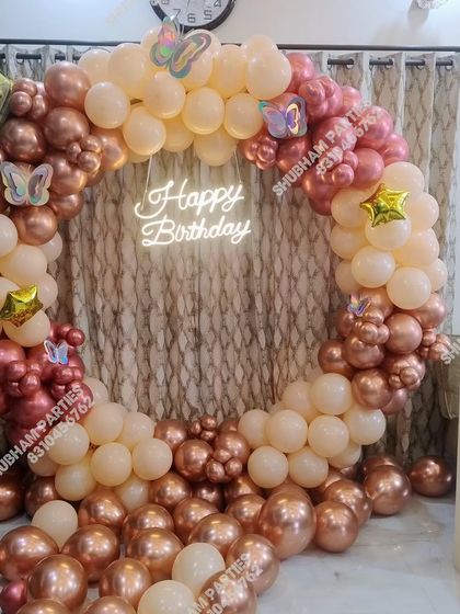 A beautiful rose gold and peach balloon ring with butterfly accents and a neon sign.