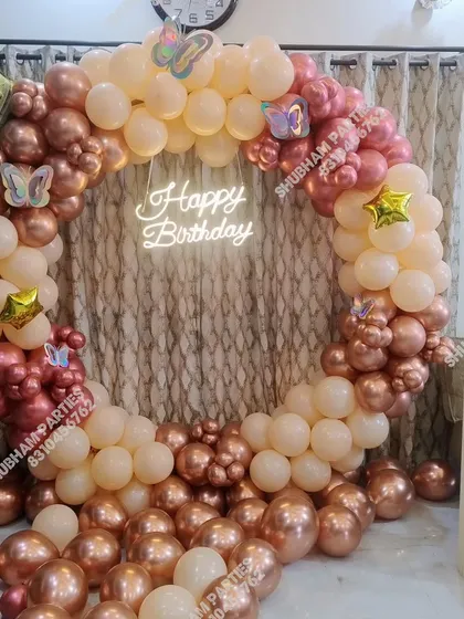 A beautiful rose gold and peach balloon ring with butterfly accents and a neon sign.