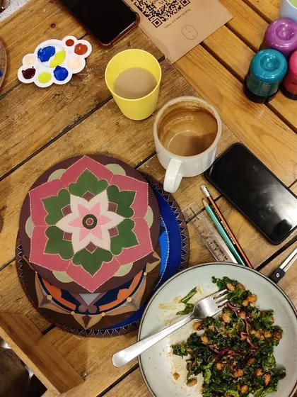 Art, coffee, and a nourishing meal. This overhead shot captures the perfect blend of creativity and comfort at our workshops.