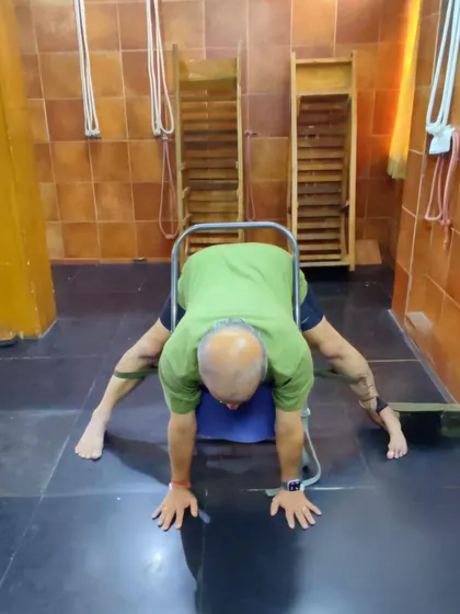 A wide-legged forward bend using a chair.