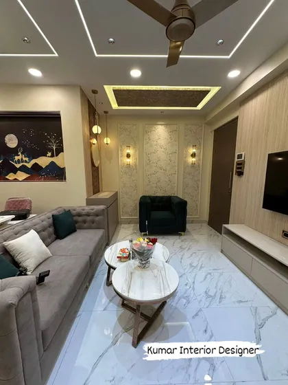 The living room features a comfortable tufted sofa, a central coffee table, and a sophisticated color palette of grey, beige, and emerald green.