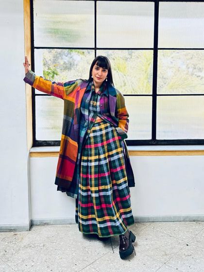 Layering is my favorite part of Delhi winters. Here, I'm wearing a colorful plaid coat and skirt set, a perfect example of my love for patterns and colors.