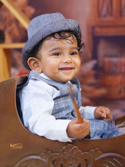 A big, beautiful smile from this charming little boy. His happiness lights up the entire photo.