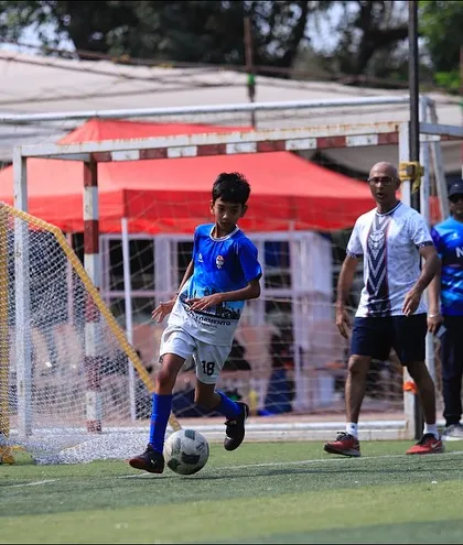 Dribbling towards the goal, a player from our U13 squad takes on the defense.
