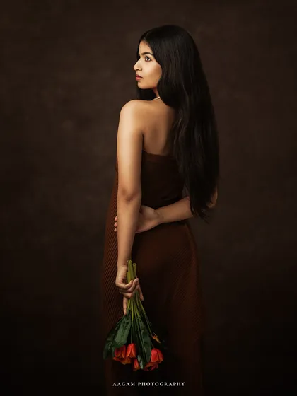 The poetry of presence, captured in light. This pose, with flowers held behind her back, adds a touch of mystery and romance to the portrait.