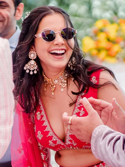 A joyful, laughing shot. The bride's minimal makeup and sunglasses create a chic and relaxed vibe.