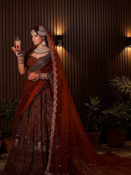 The full-length view of this regal bridal look. The flowing dupatta and grand lehenga create a silhouette of timeless elegance.